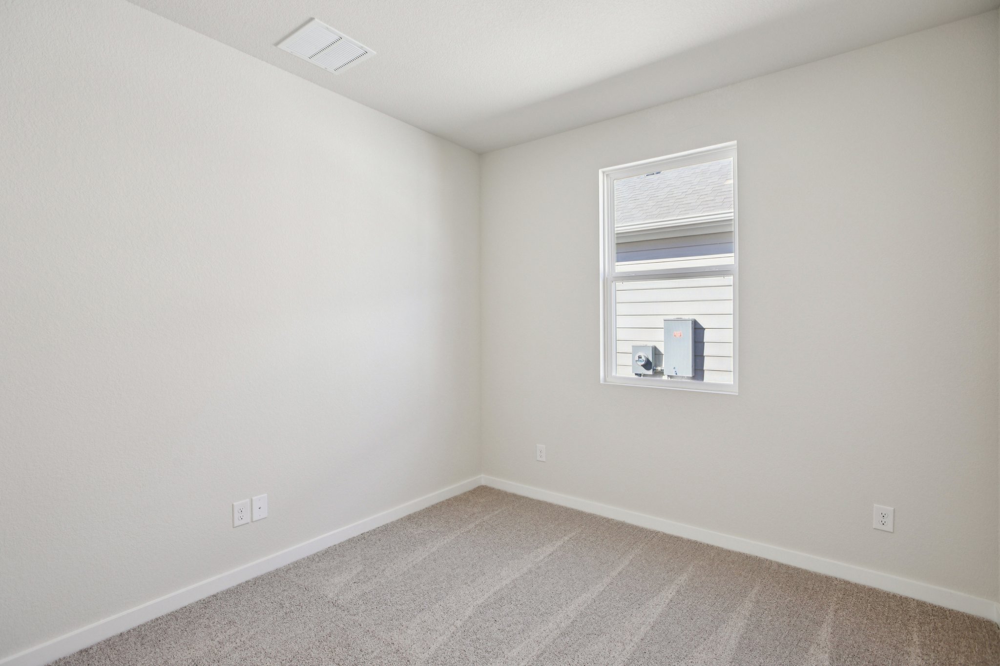 A room with a window and a carpet.