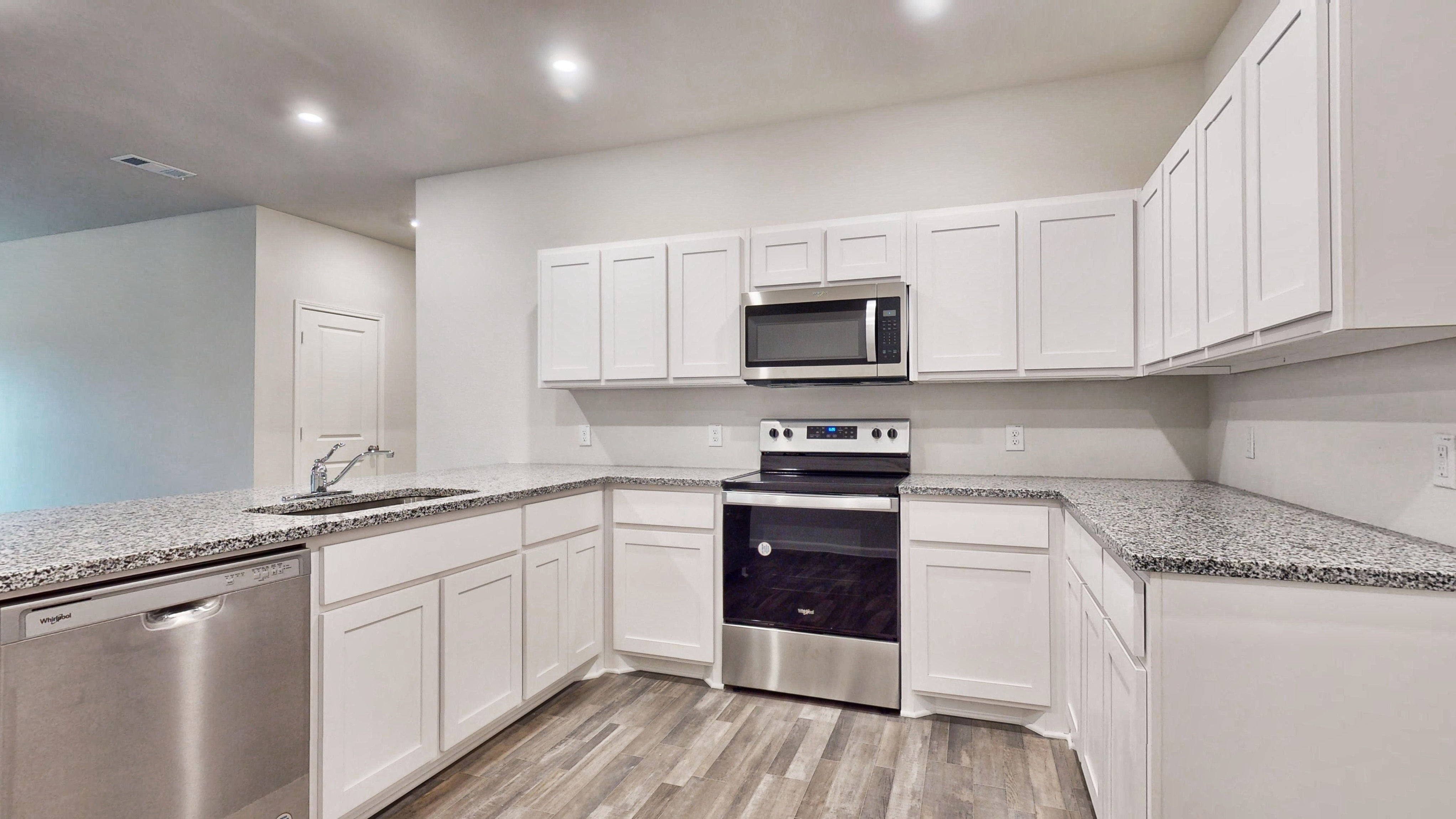 A kitchen with white cabinets.