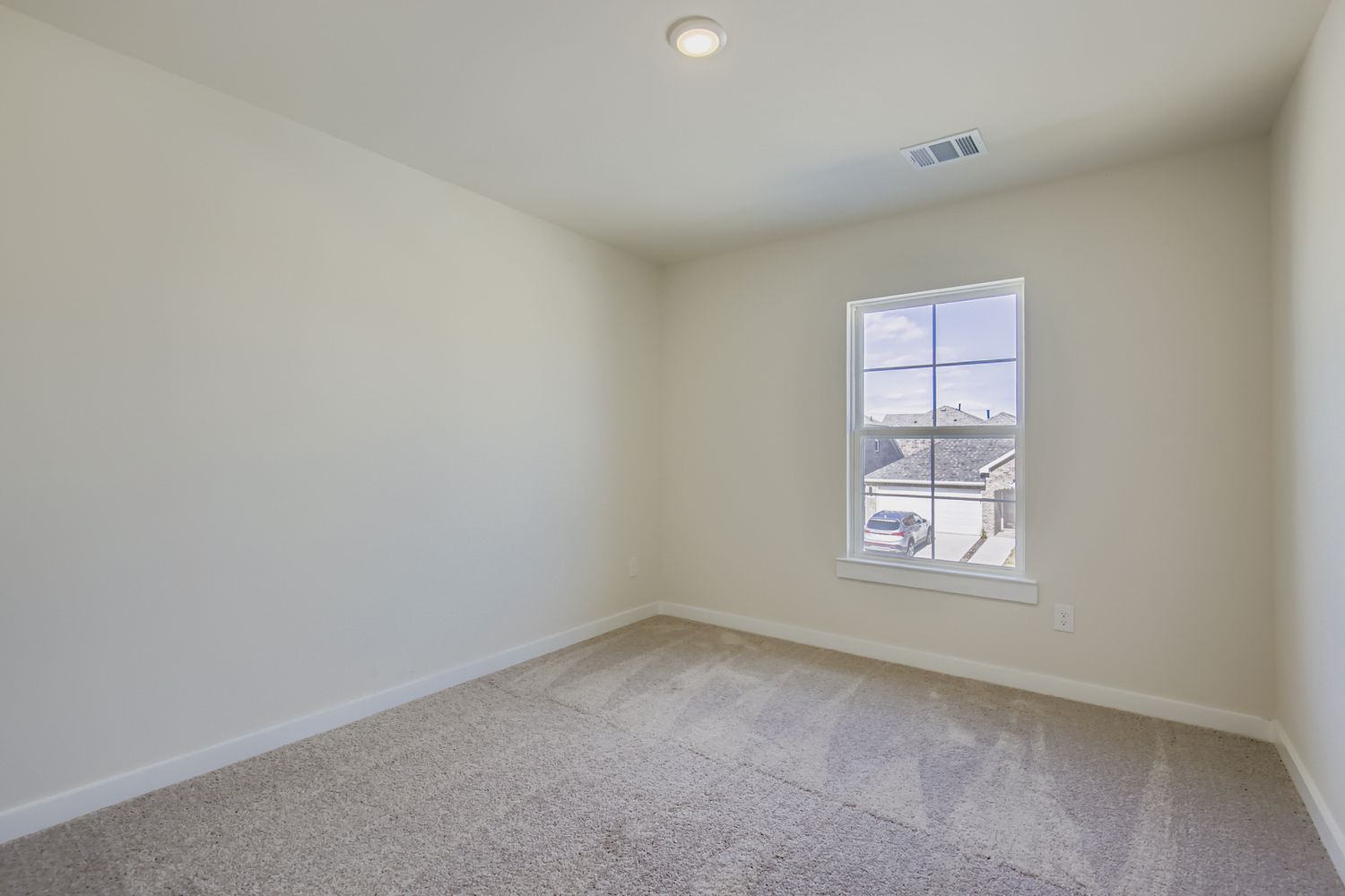 A room with a window and a carpet.