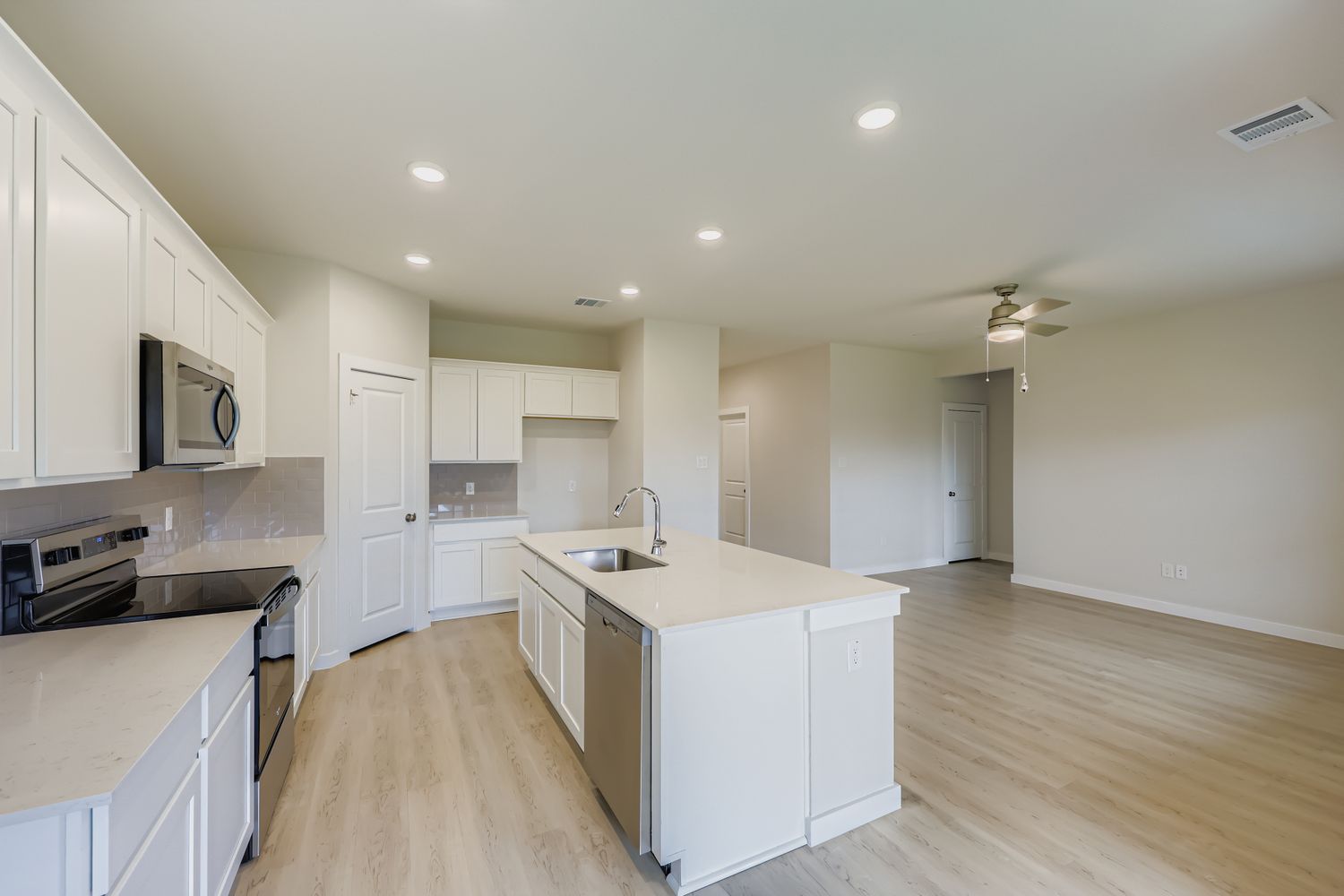 A kitchen with white cabinets.
