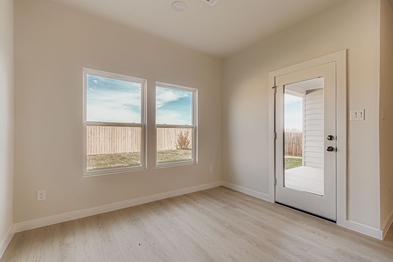A room with a wood floor and a door with a window.
