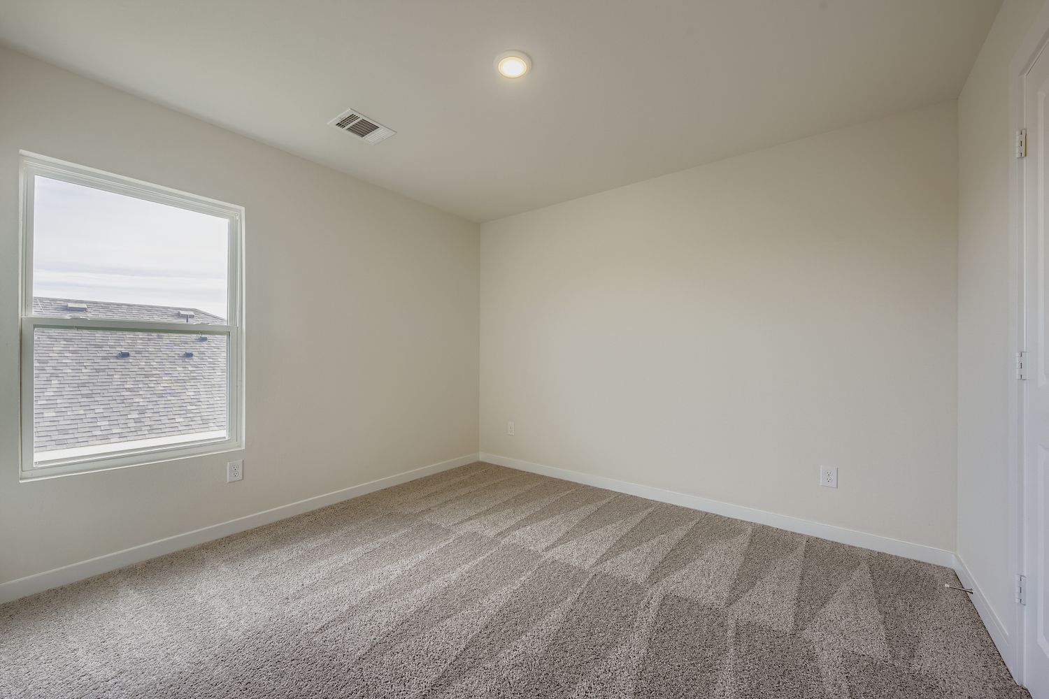 A room with a carpet and a window.