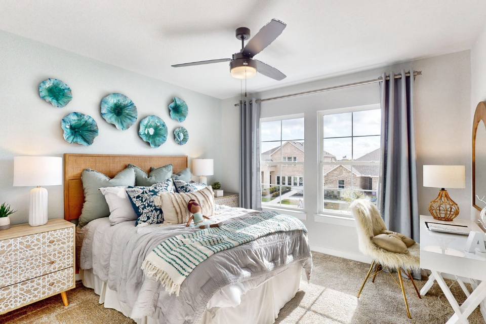 A bedroom with a bed and a fan.