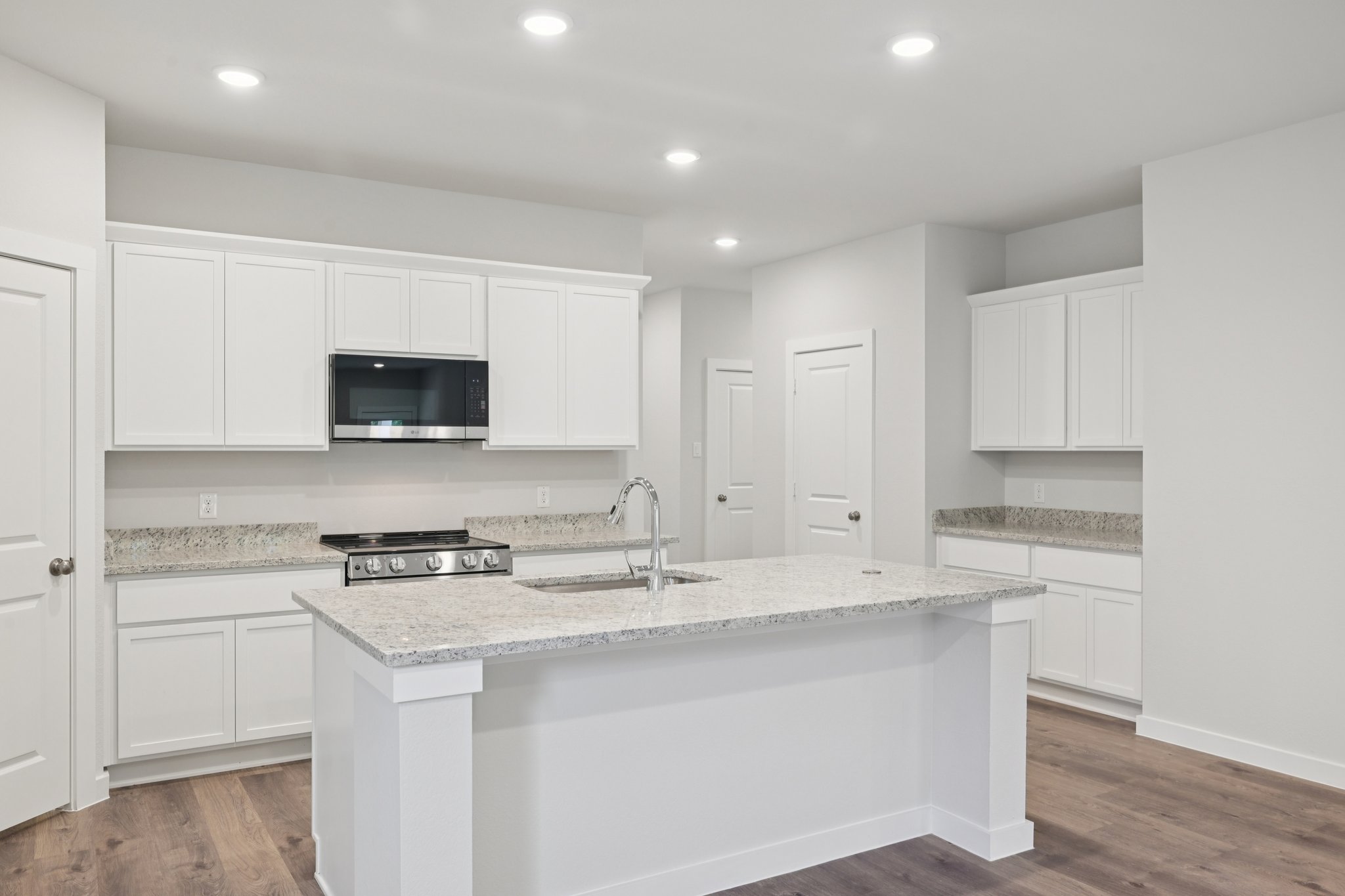 A kitchen with white cabinets.