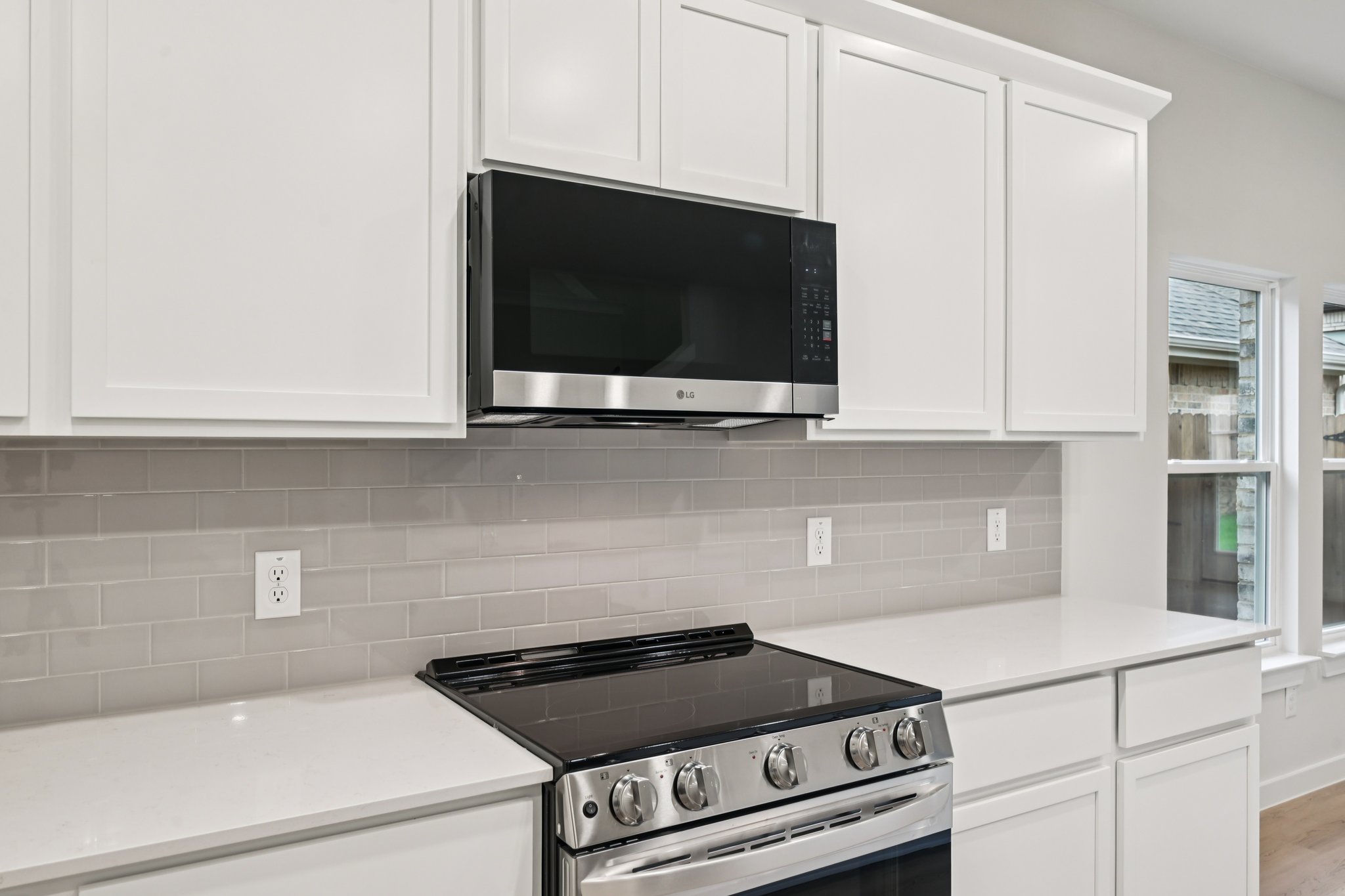 A kitchen with white cabinets.
