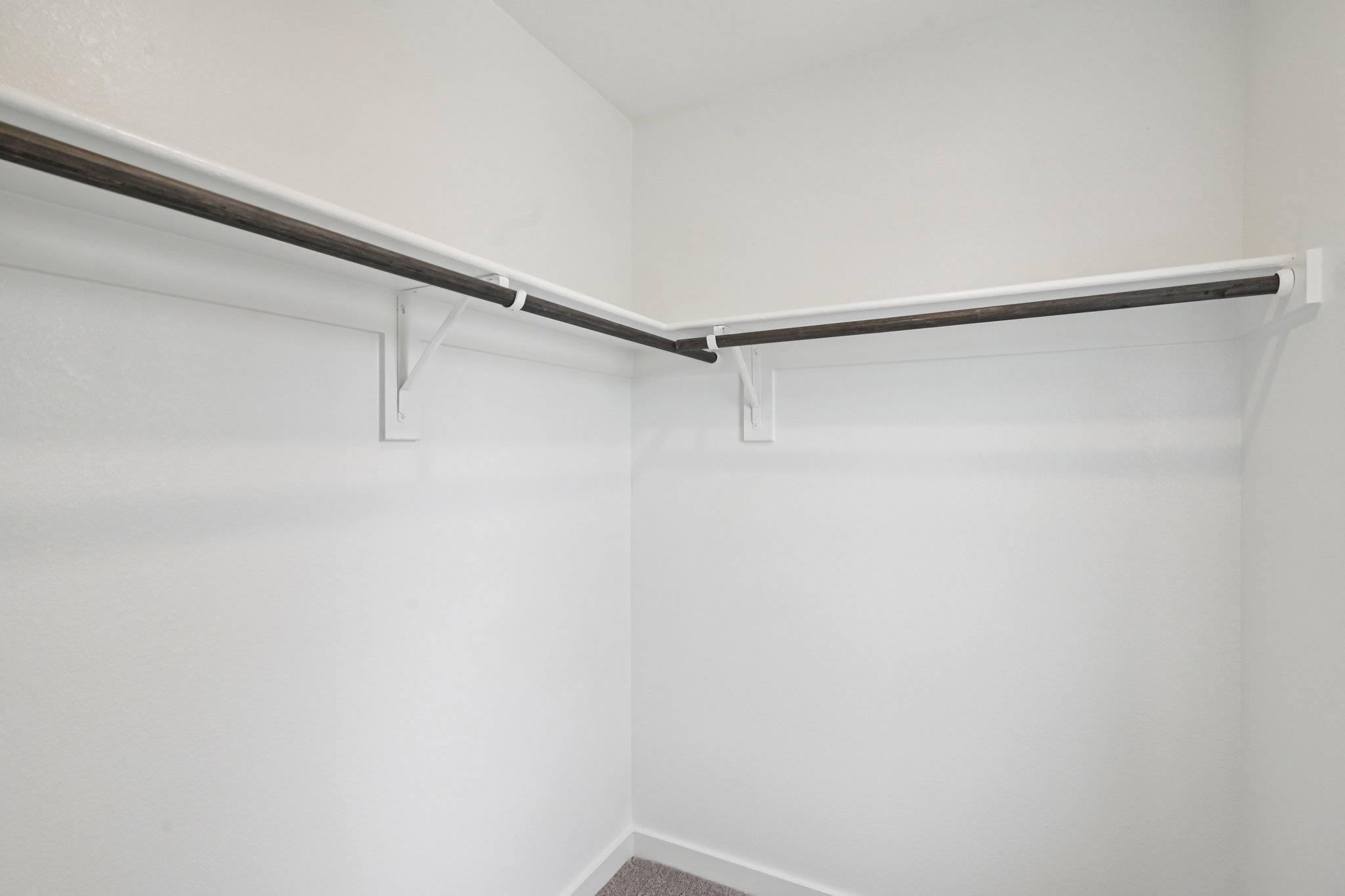 A white wall with a metal bar.