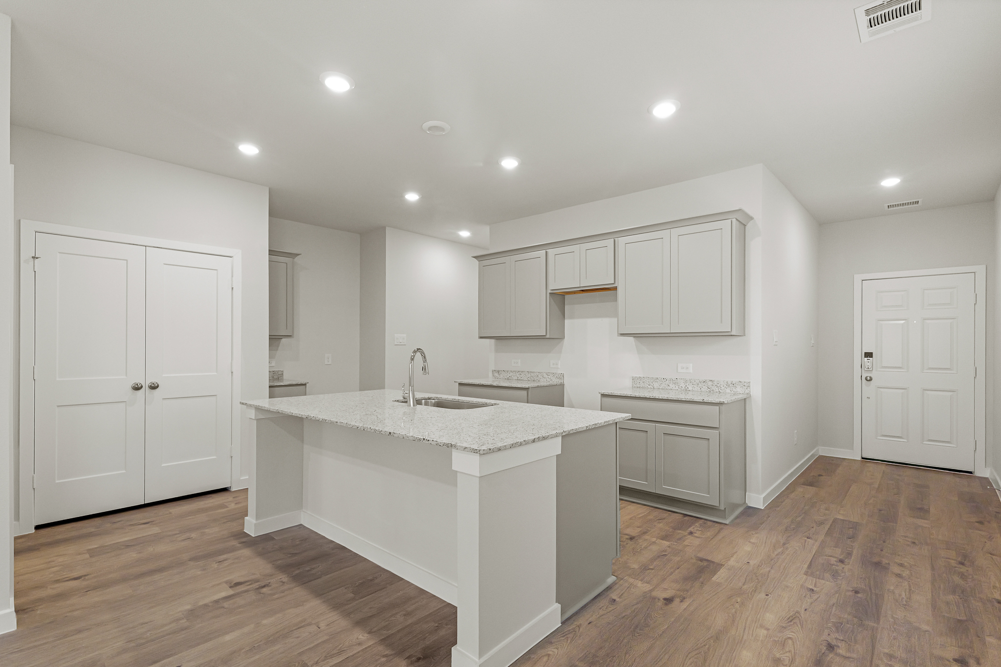 A kitchen with white cabinets.