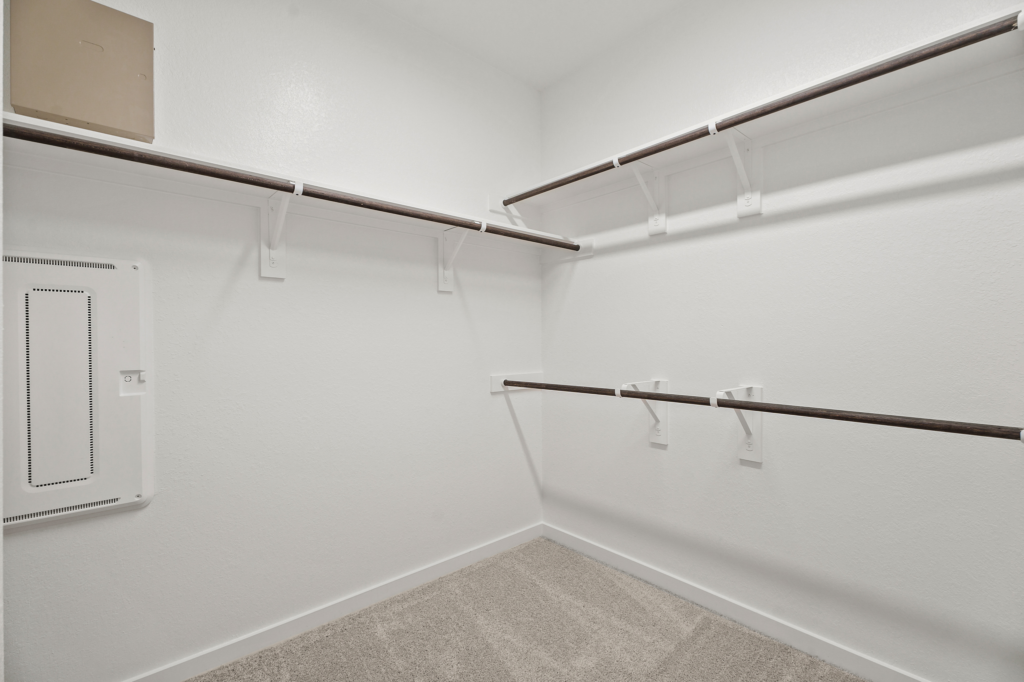 A white wall with a metal bar.