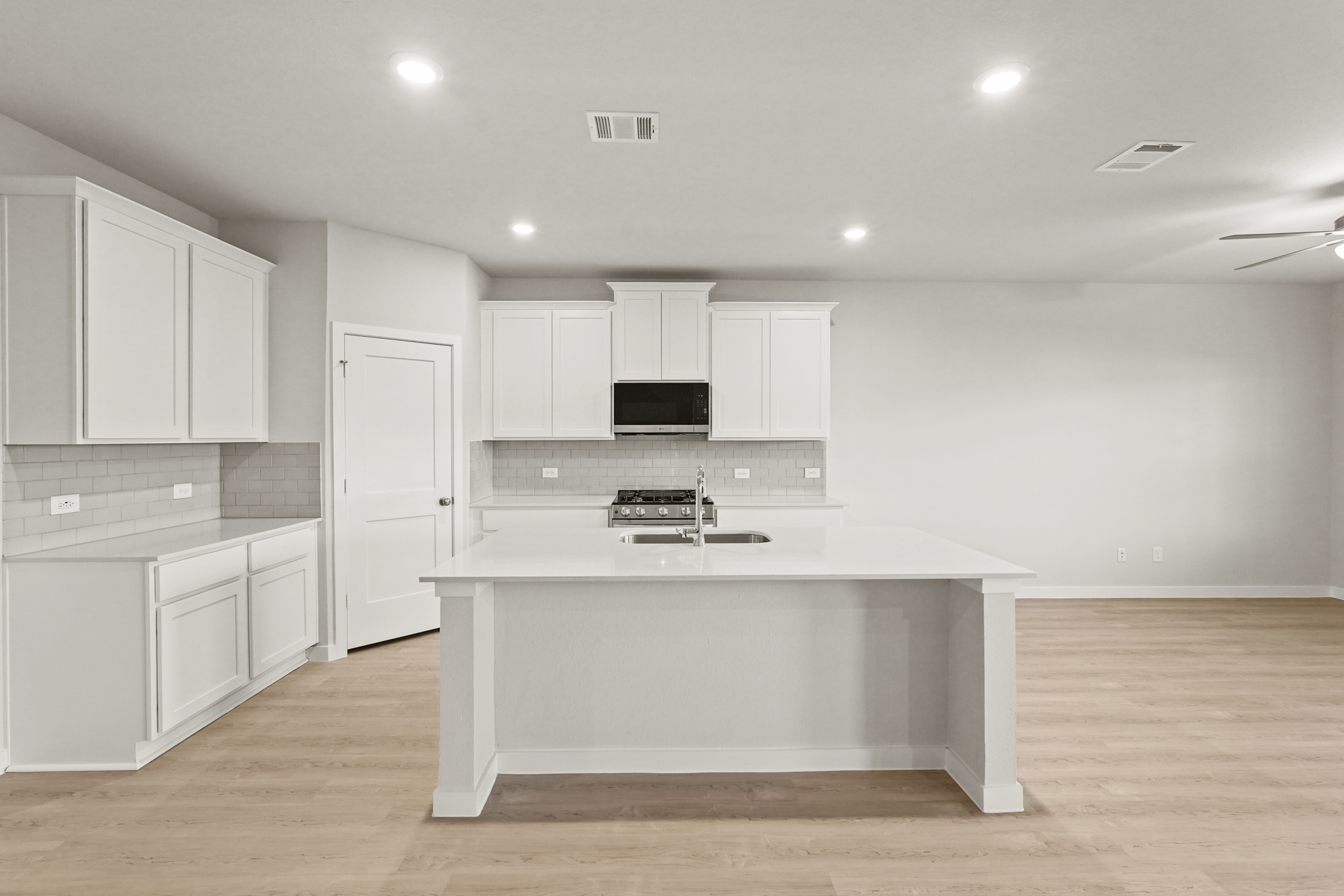 A kitchen with white cabinets.