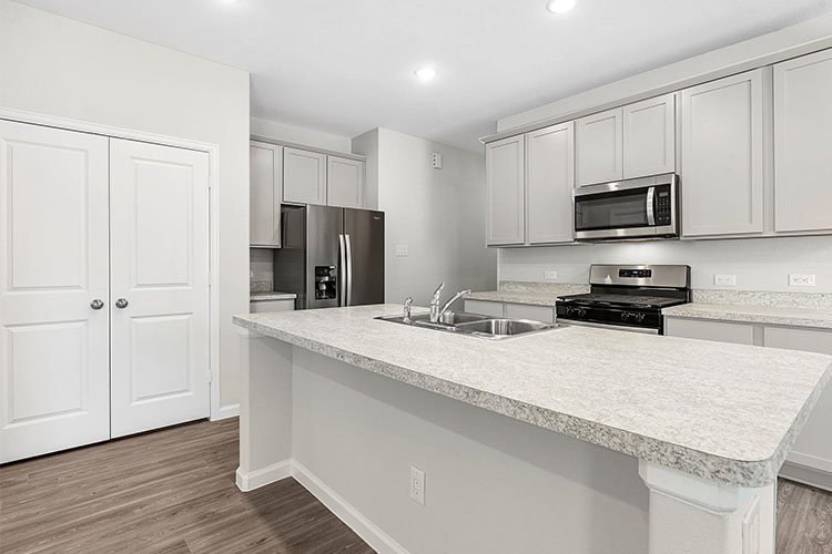 A kitchen with white cabinets.