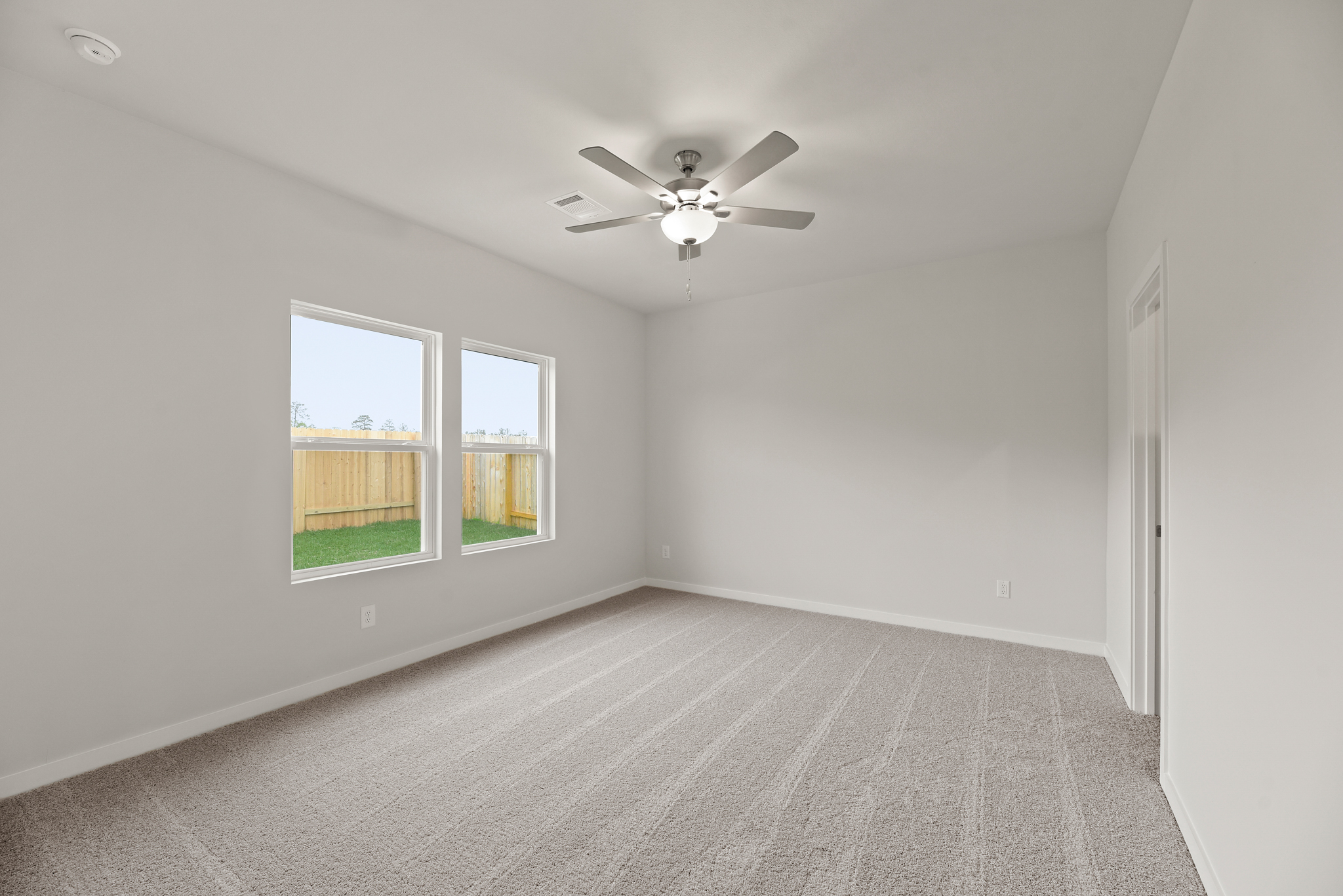 A room with a ceiling fan and a window.