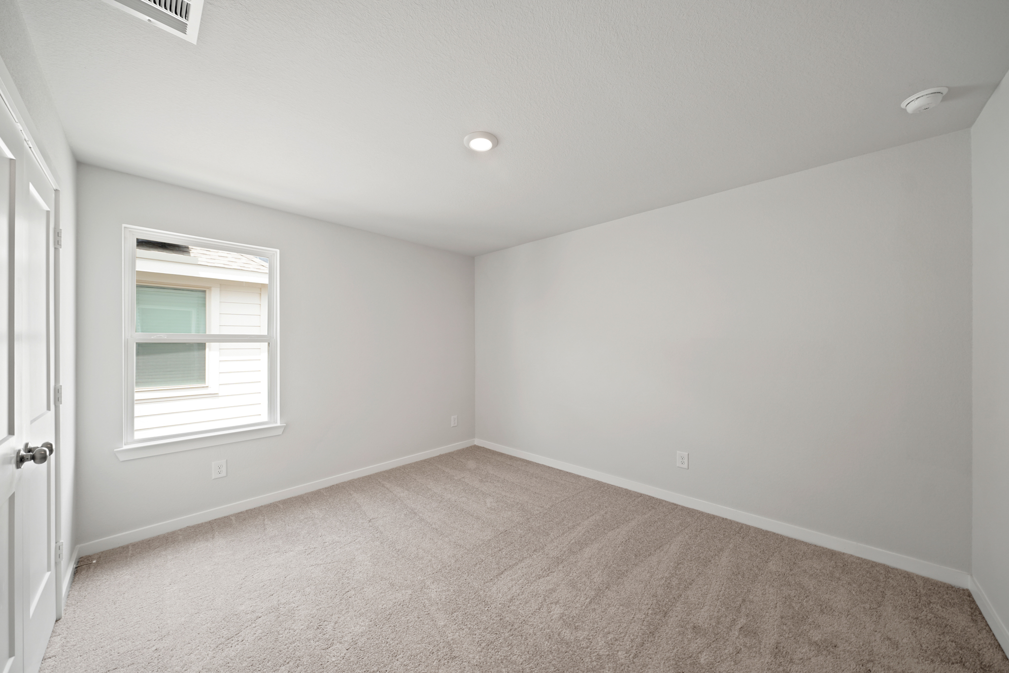 A room with a carpet and a window.