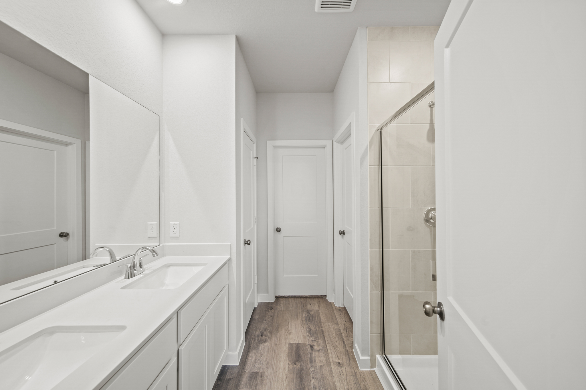 A bathroom with white cabinets.