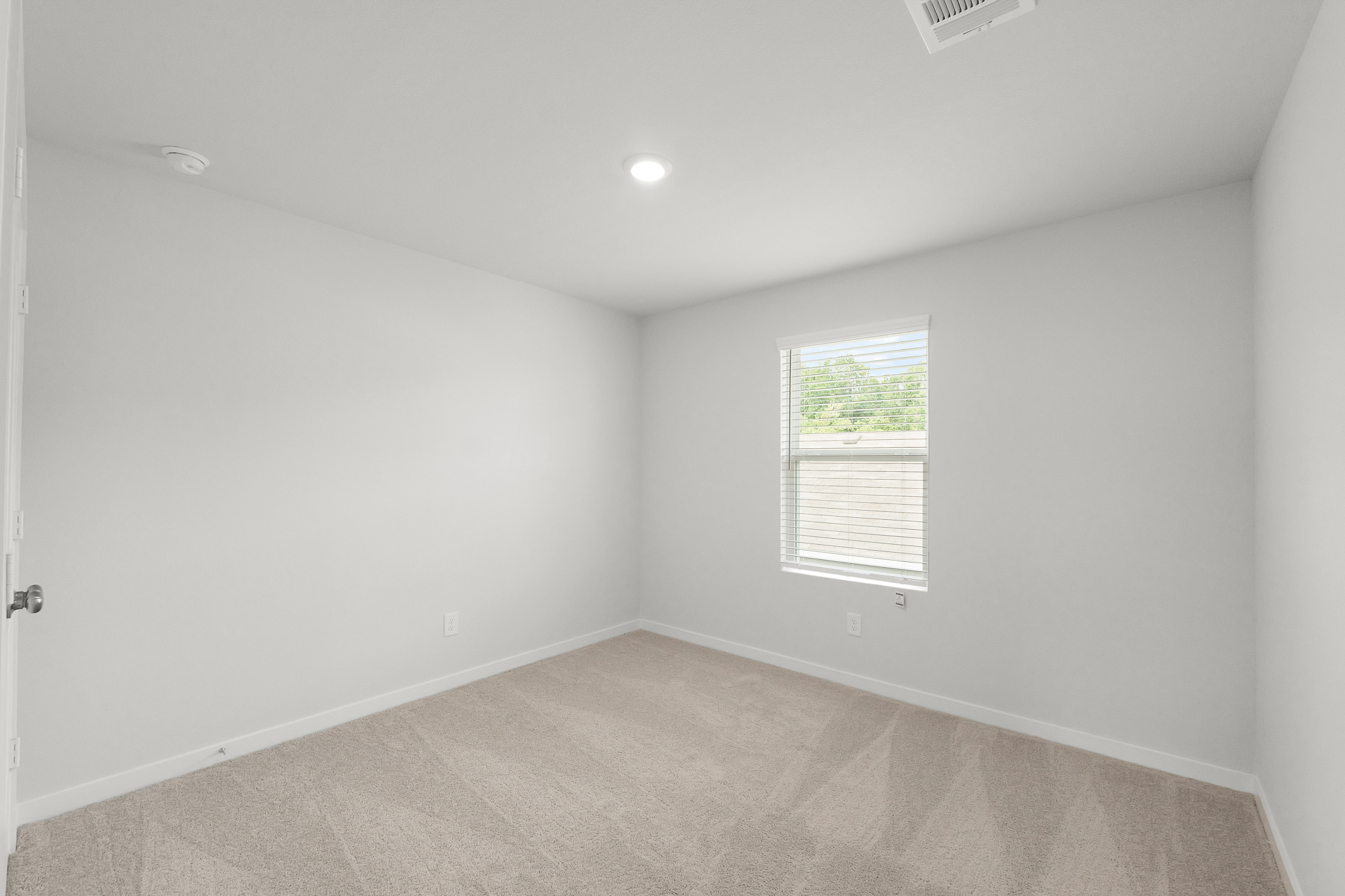 A room with a window and a carpet.