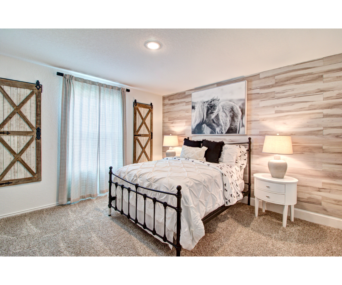 A bedroom with a bed and a lamp.