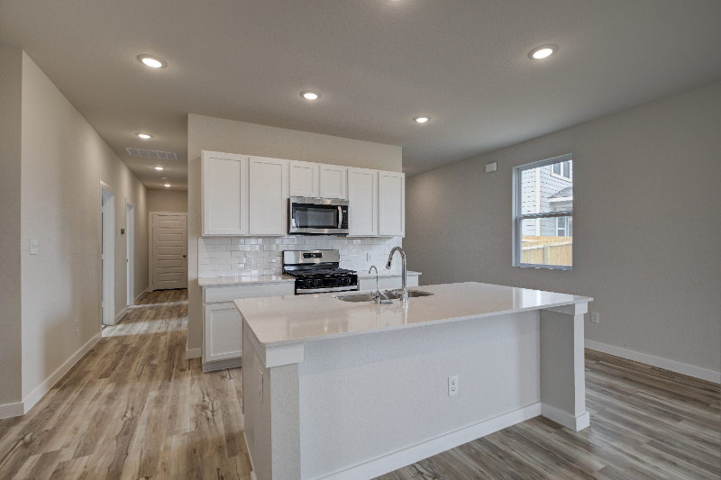 A kitchen with white cabinets.