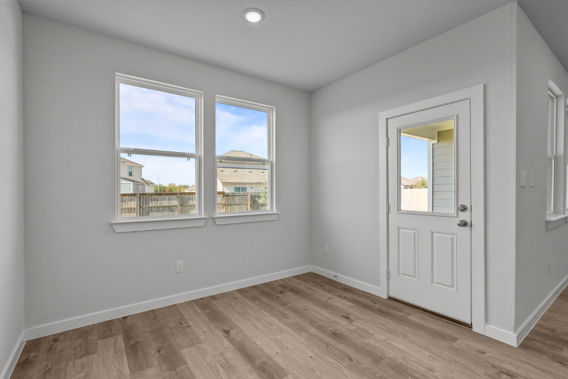 A room with a wood floor and a white door with a window.