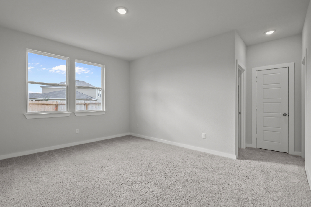 A room with a window and a door with a view of the city.