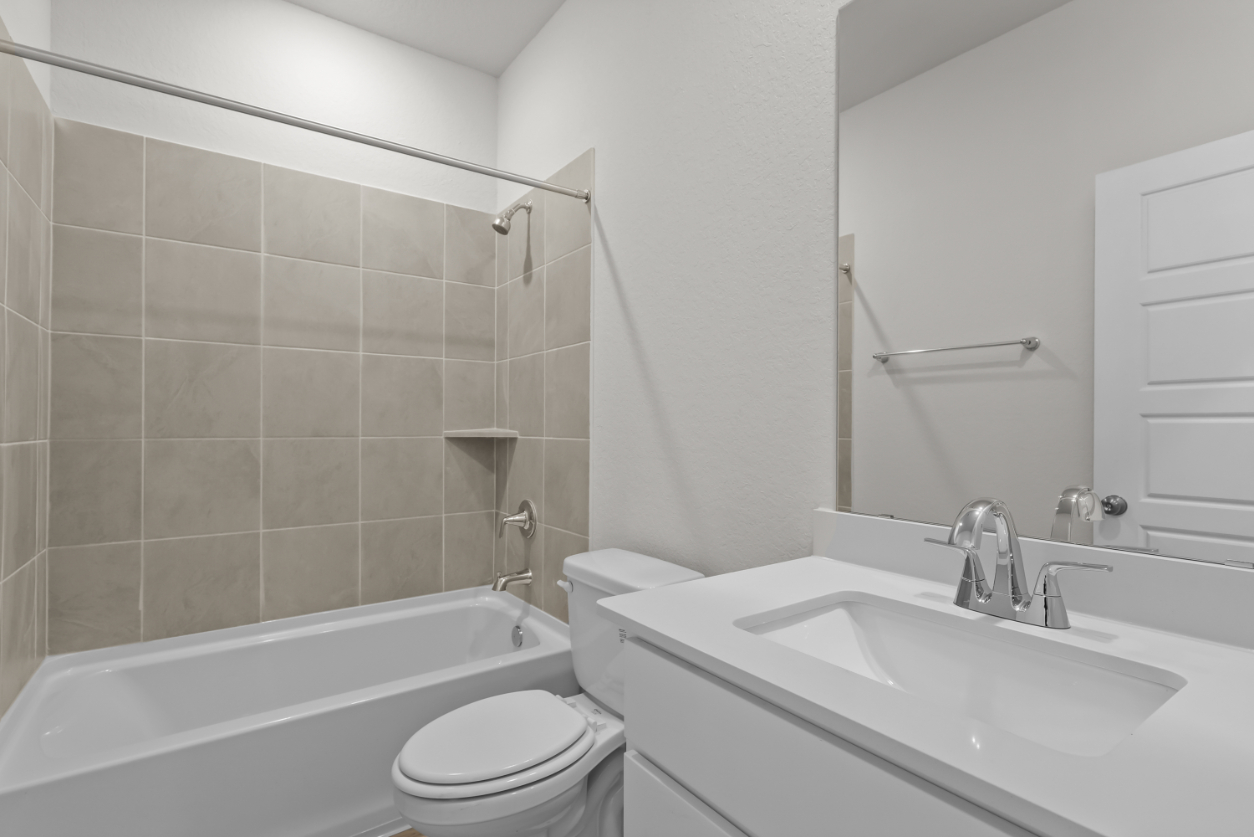 A bathroom with a sink toilet and bathtub.