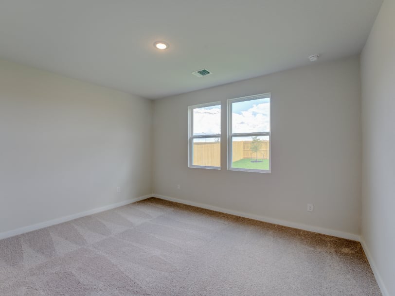 A room with a window and a carpet.