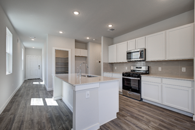 A kitchen with white cabinets.