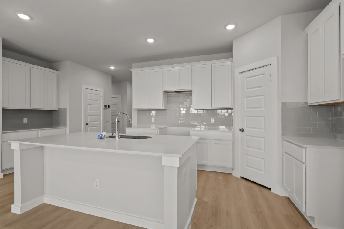 A kitchen with white cabinets.