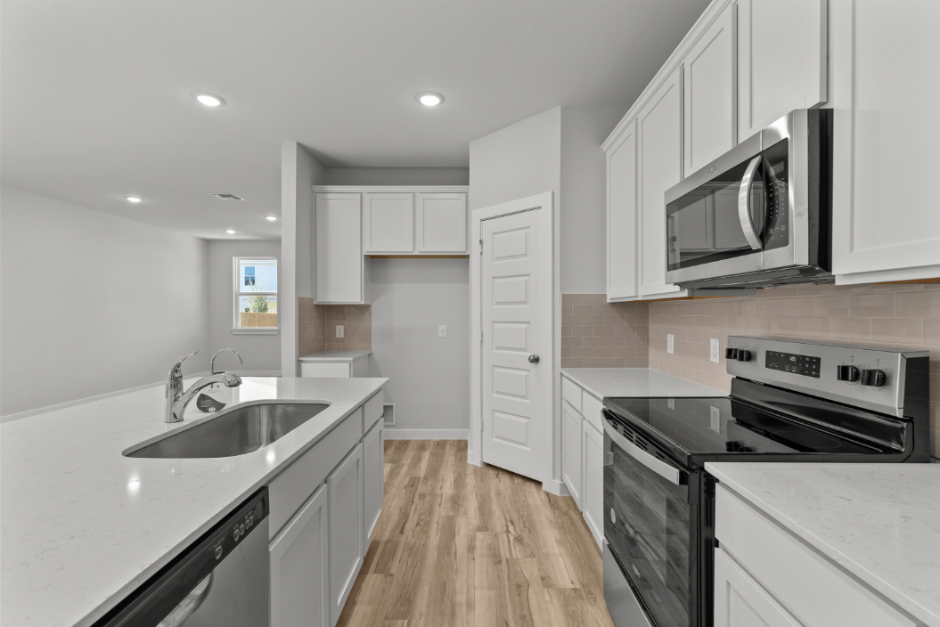 A kitchen with white cabinets.
