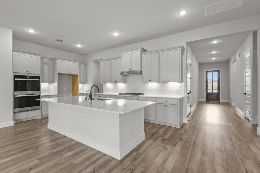 A kitchen with white cabinets.