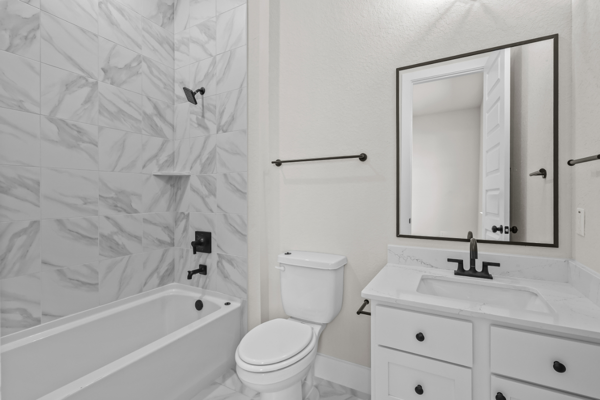 A bathroom with a tub toilet and sink.