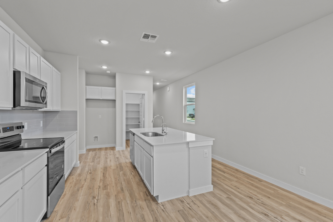 A kitchen with white cabinets.