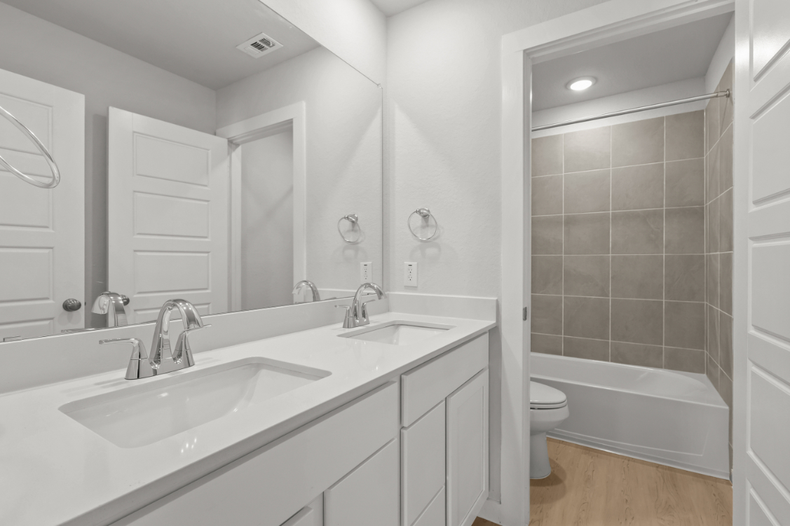 A bathroom with a tub sink and toilet.