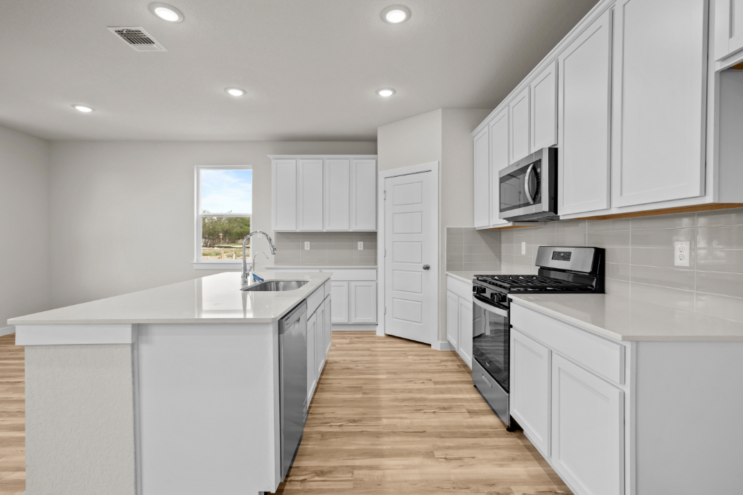 A kitchen with white cabinets.