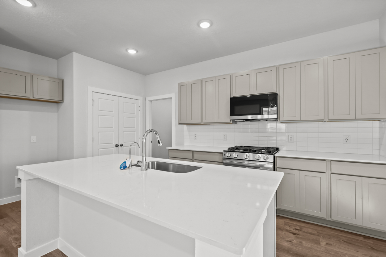 A kitchen with white cabinets.