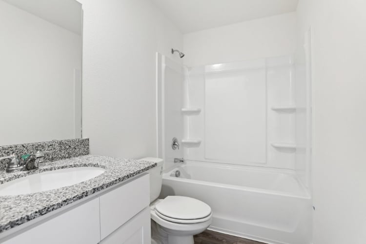 A bathroom with a tub sink and toilet.