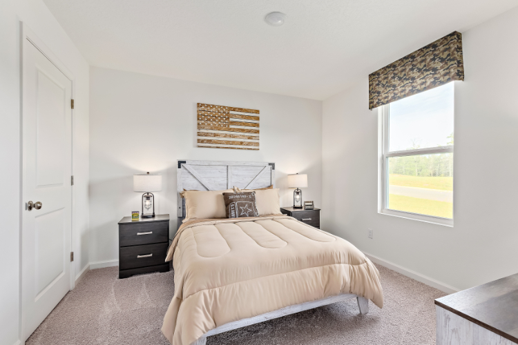 A bedroom with a bed and a window.