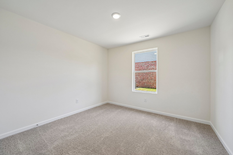 A room with a carpet and a window.