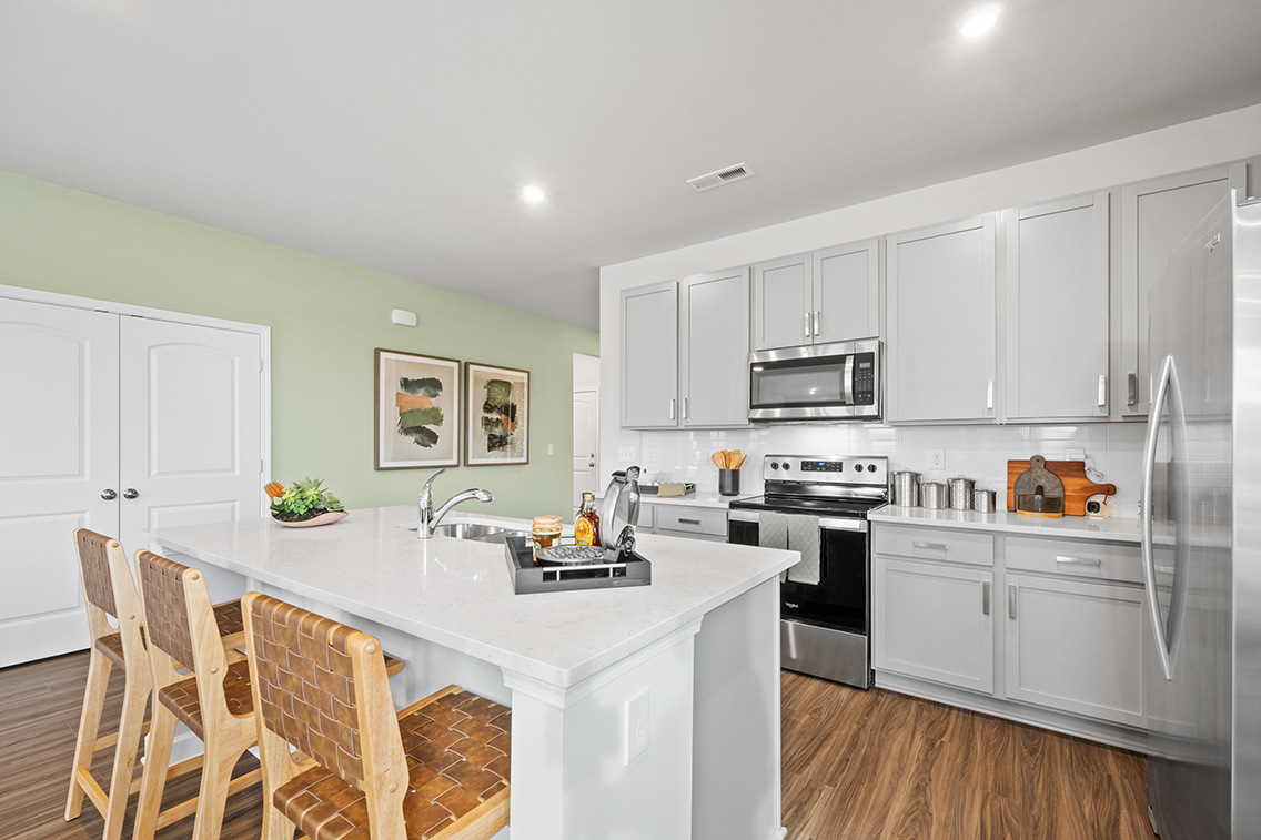 A kitchen with white cabinets.