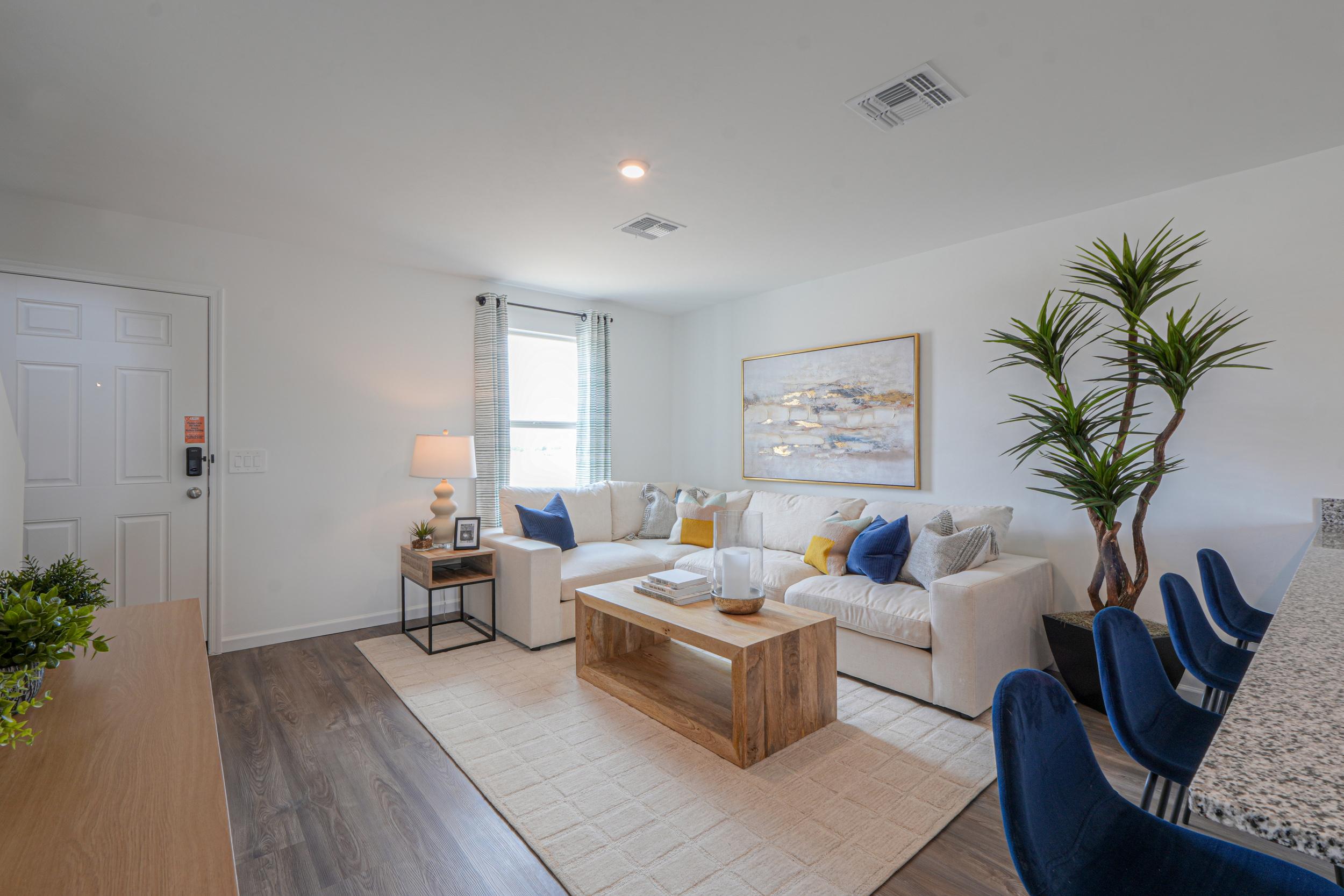 A living room with a white couch and a wood floor.