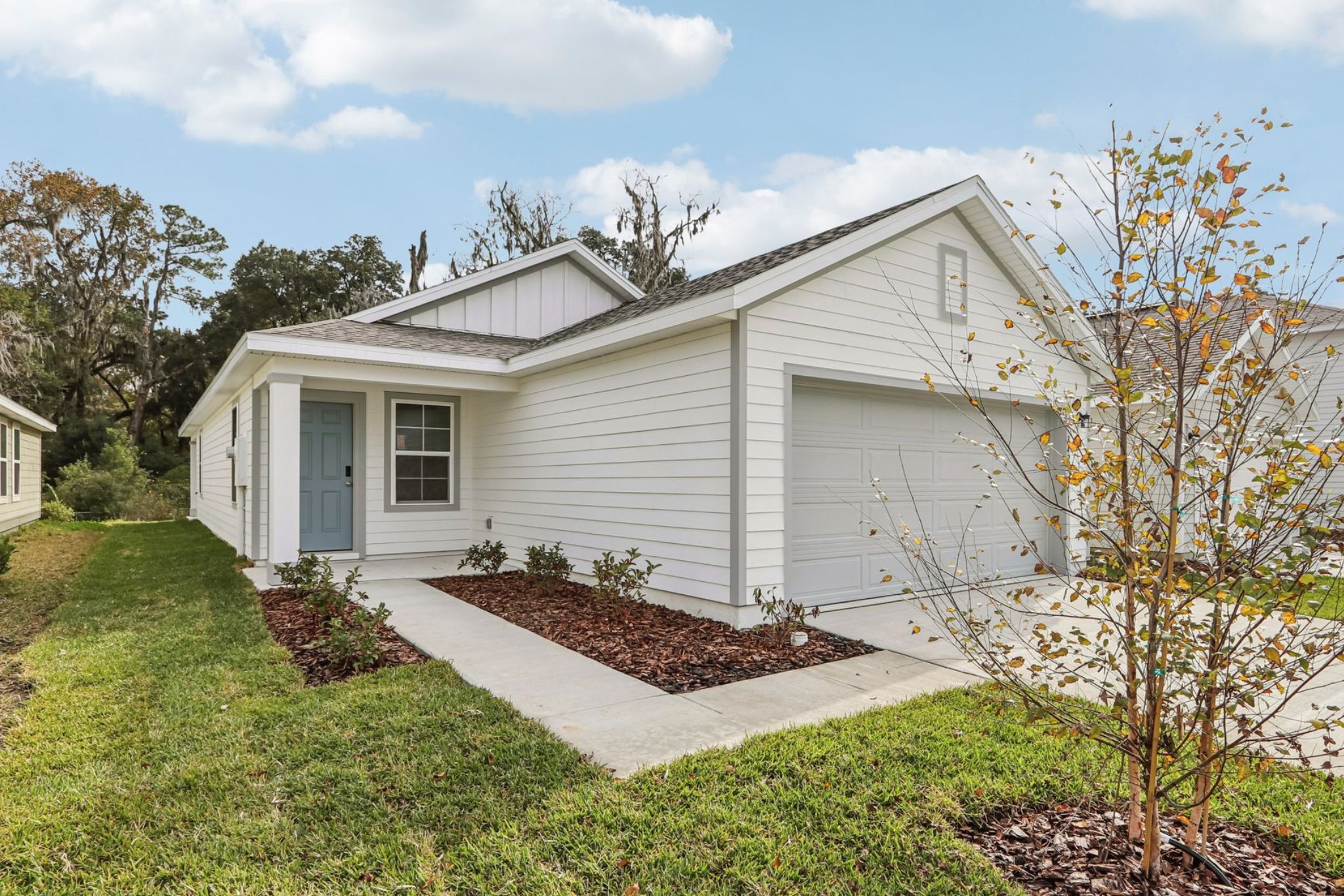 A white house with a small garden with Carl Sandburg Home National Historic Site in the background.
