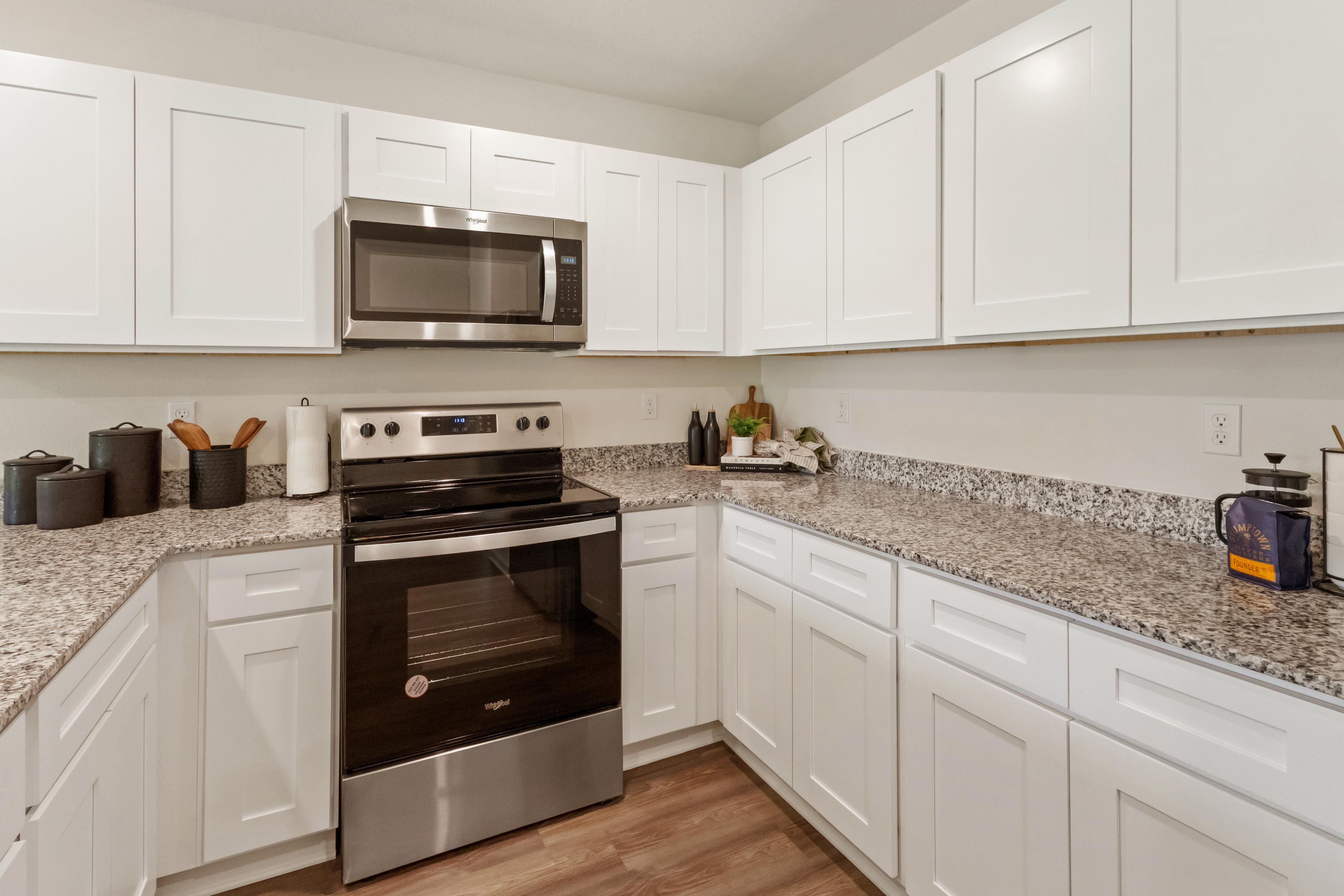 A kitchen with white cabinets.